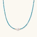 Dainty teal apatite beaded necklace with a single freshwater pearl centerpiece flanked by two small gold beads, adjustable gold clasp.